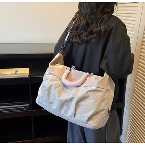 Detail of grey and pink large travel tote bag with nylon texture and shoulder strap