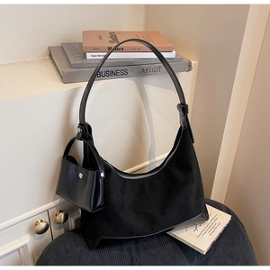 Detail of minimalist black hobo bag with matte suede texture and silver zipper detail