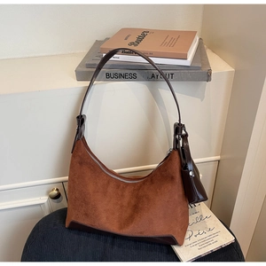 Detail of brown faux suede hobo tote bag with mini pouch on a black corduroy seat
