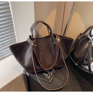 Détail d'un grand cabas vintage en cuir ciré marron foncé avec doubles anses