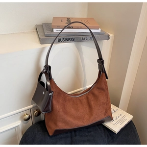 Detail of caramel suede hobo bag with dark leather trim and mini pouch attachment