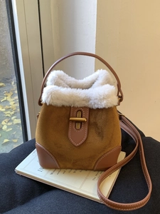 Vintage brown suede bucket bag with white faux fur trim and gold buckle detail