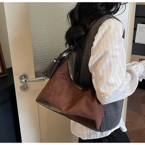 Detailed close-up of the vintage brown suede hobo bag with leather patchwork and pouch