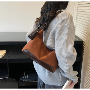Close-up of caramel hobo tote bag in frosted suede with leather strap on a model