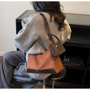 Detail of vintage brown suede tote bag with contrast leather trim and mini pouch accessory