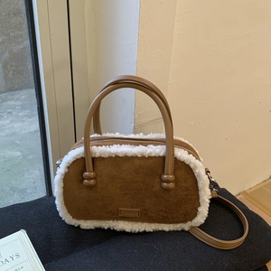 Gros plan du sac bowling en daim marron avec bordure en fausse fourrure blanche et patch