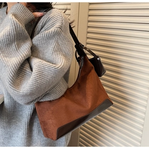 Detail of hobo shoulder bag in brown suede with leather straps and mini coin purse