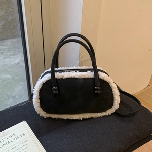 Détail du sac bowling rétro en daim noir avec bordure en fausse fourrure blanche