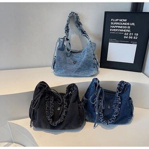 Detailed view of denim shoulder bags with pleated handles and decorative side bows