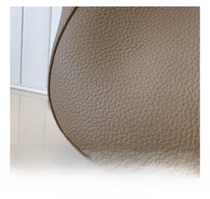 Gros plan du sac en cuir grainé marron avec logo argenté et détails de texture