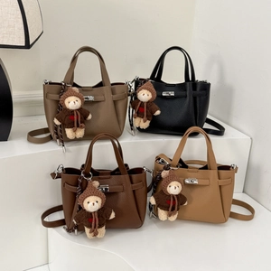 Détails de quatre sacs seau en cuir grainé avec des breloques d'ours en peluche