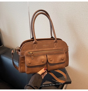 Detail shot of vintage brown tote bag with twin front flap pockets and golden brand logo