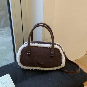 Détail du sac bowling d'hiver en daim marron foncé avec bordure en polaire blanche