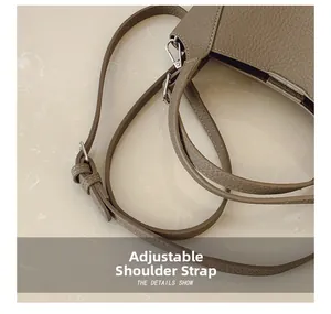 Détail du cuir grainé litchi et de la boucle métallique réglable du sac à bandoulière