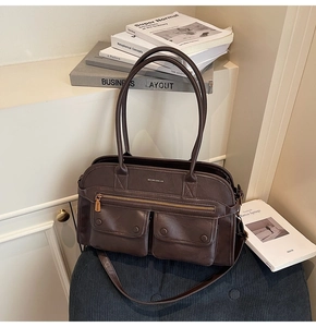 Detail of dark brown tote bag with zipper pocket and magnetic buckle compartments
