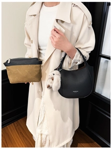 Détail du sac à main en cuir texturé avec pochette en toile et breloque lapin en peluche