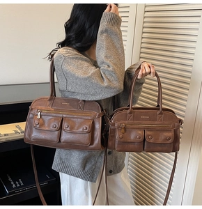 Detail view of large and small retro brown leather tote bags with front pockets and zippers