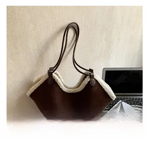 Detail of suede tote bag featuring white faux shearling trim and brown leather straps