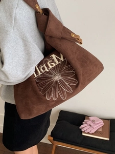 Brown suede tote bag with daisy and Napli embroidery shown on model for autumn winter style