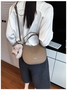Sac seau demi-lune en cuir beige avec un adorable accessoire de lapin en peluche