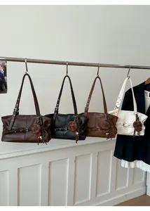 Detail view of retro tote bags in four colors with buckle straps and plaid charms