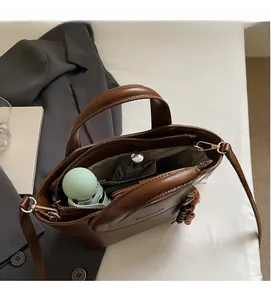 Detailansicht des geräumigen Innenlebens einer braunen Leder-Eimertasche mit Reißverschluss