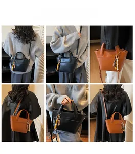 Detailansichten der Retro-Beuteltasche in Schwarz und Braun mit Perlenanhänger