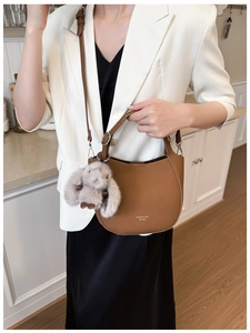 Détail du sac demi-lune en cuir marron avec charmant pendentif lapin en peluche