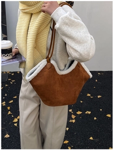 Detail of suede tote bag featuring plush faux shearling trim and brown leather handles