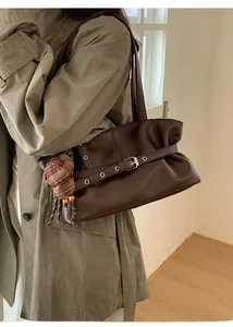 Detailed view of dark coffee faux leather tote with vintage buckle and silver eyelets