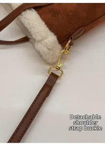 Detailed close-up of brown suede bucket bag with gold clasp and fleece trim