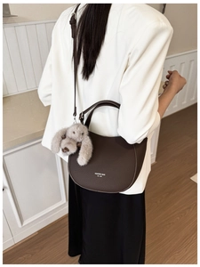 Détail du sac demi-lune en cuir marron foncé avec pendentif lapin en peluche