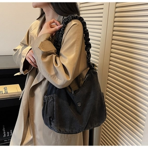 Detail of black large capacity hobo bag featuring ruched strap and side elastic pocket