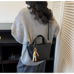 Detailansicht der schwarzen Kunstleder-Eimertasche mit dekorativen bunten Holzperlen