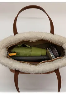 Overhead view showing interior capacity of a brown bucket bag with white plush trim