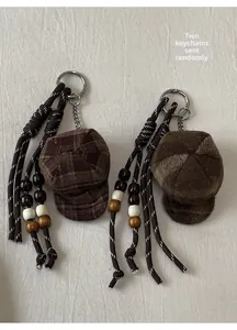 Detail of two retro beret charms with plaid fabric, plush material and wooden beads
