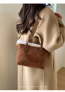Brown retro bucket bag in suede with sherpa trim worn by model in camel wool coat