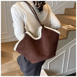 Detail of dark brown suede tote with white faux fur trim and leather shoulder strap