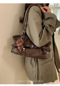 Detail of dark brown retro shoulder bag with a creative plaid hat charm accessory