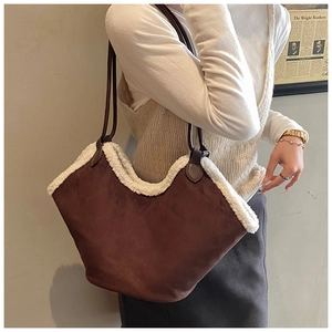 Detail of suede underarm bag with faux shearling trim and slim leather shoulder straps