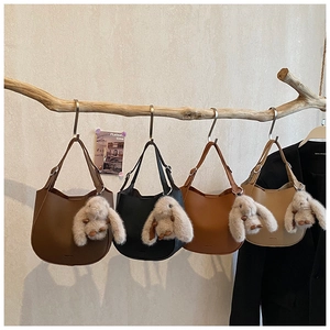 Selection of four chic hobo bags in assorted colors with plush bunny charms on a branch