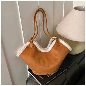 Close-up of brown suede tote bag featuring white faux shearling trim and slim leather straps