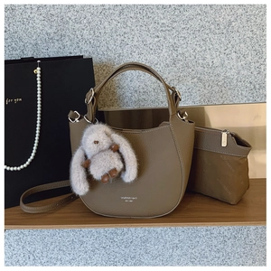 Détail du sac seau en cuir marron clair avec pochette intérieure et breloque lapin