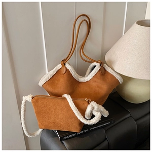 Detail of camel suede tote and pouch set with faux shearling trim and brown straps