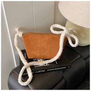Close-up of brown suede hobo bag featuring a thick white fuzzy plush shoulder strap