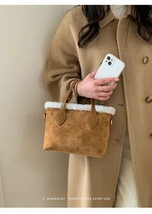 Detail of vintage brown embossed bucket bag with plush white faux fur trim and gold hardware
