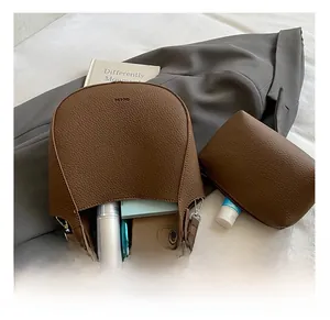 Brown litchi grain leather bucket bag showing large capacity for books and cosmetics