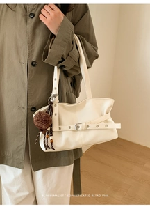 Detail of minimalist retro tote bag in cream with checkered mini hat charm accessory