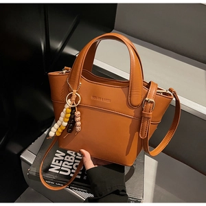 Nahaufnahme braune Beuteltasche aus Leder mit Markenlogo und bunter Perlenverzierung