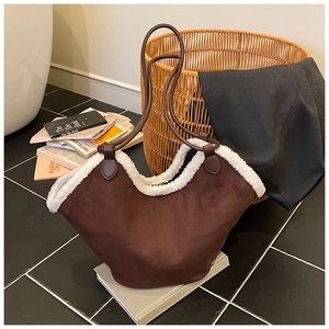 Detail of faux suede tote bag with white faux fur trim and long brown handles